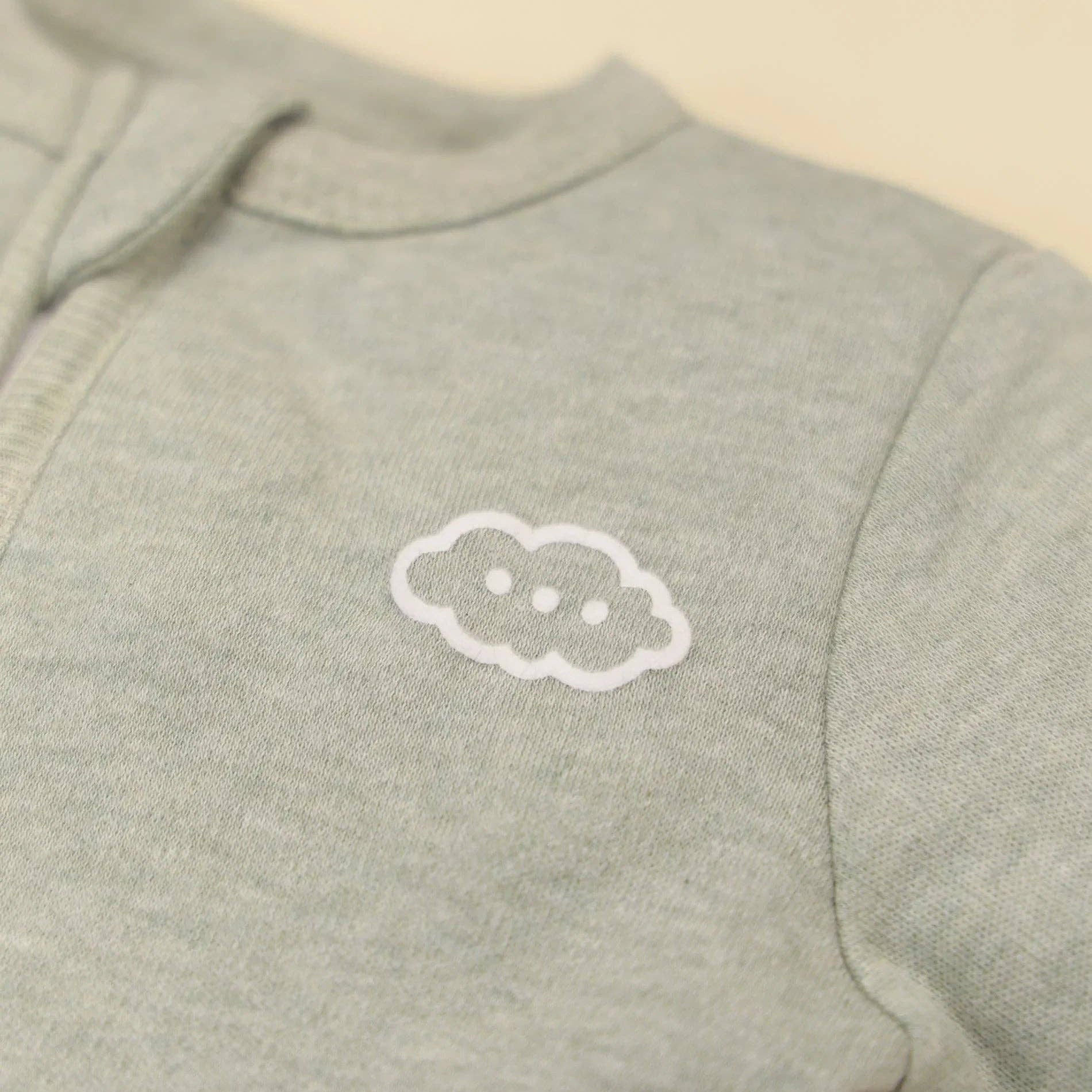 Light gray sweatshirt with a white cloud design on a beige background