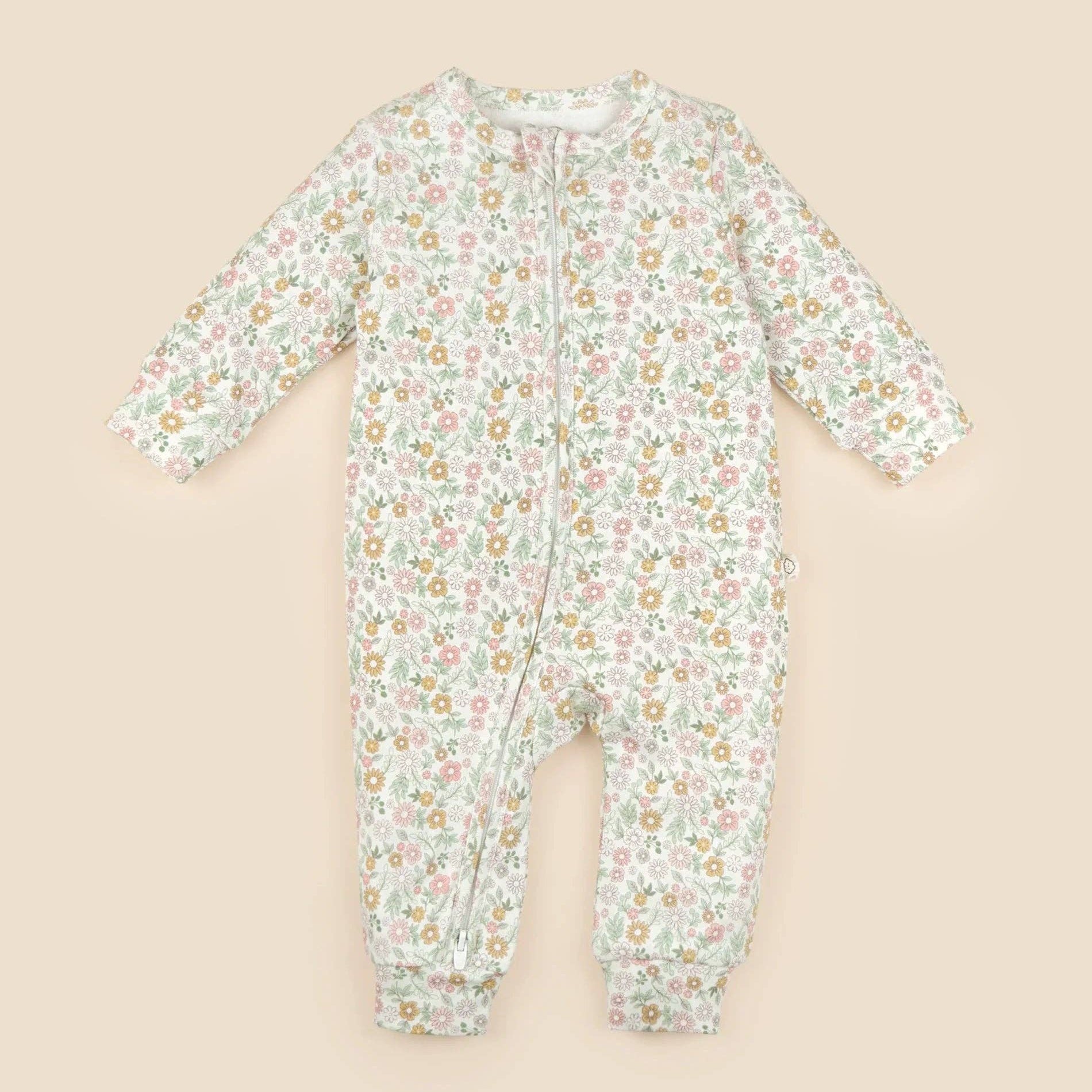 Floral-patterned baby onesie on a beige background