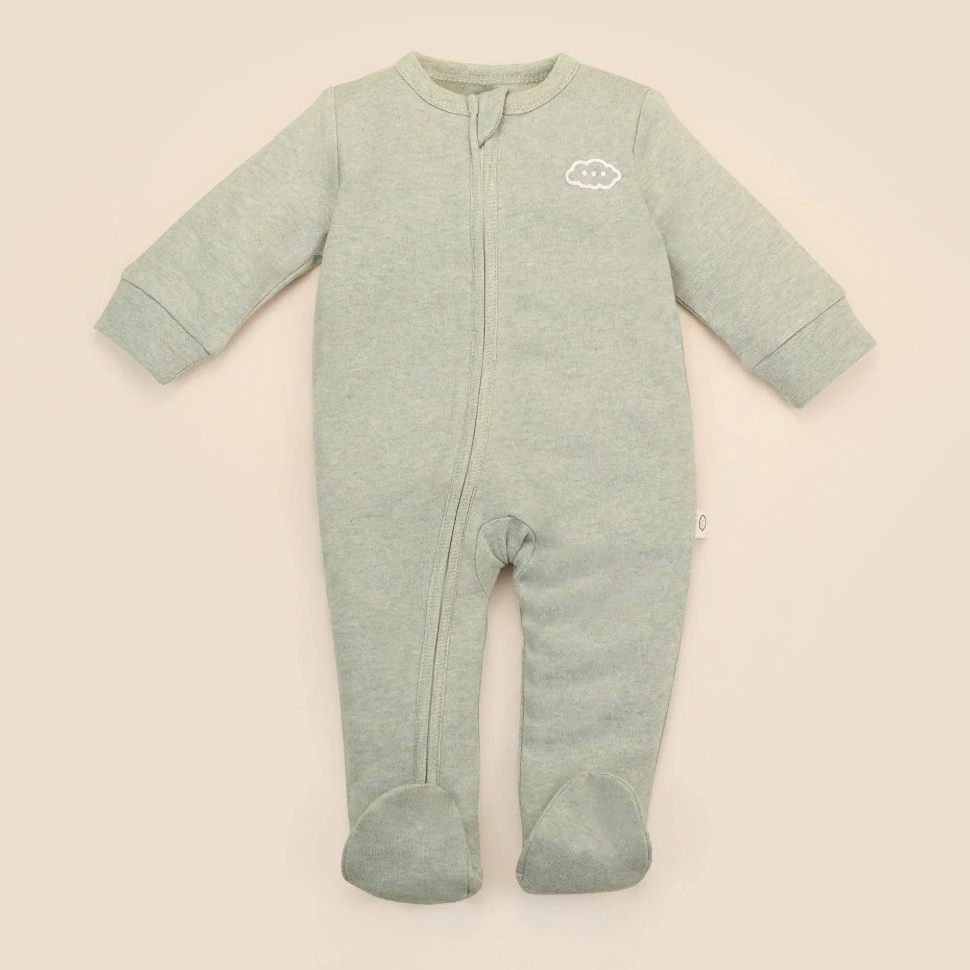 Green baby onesie with a brand logo on a beige background