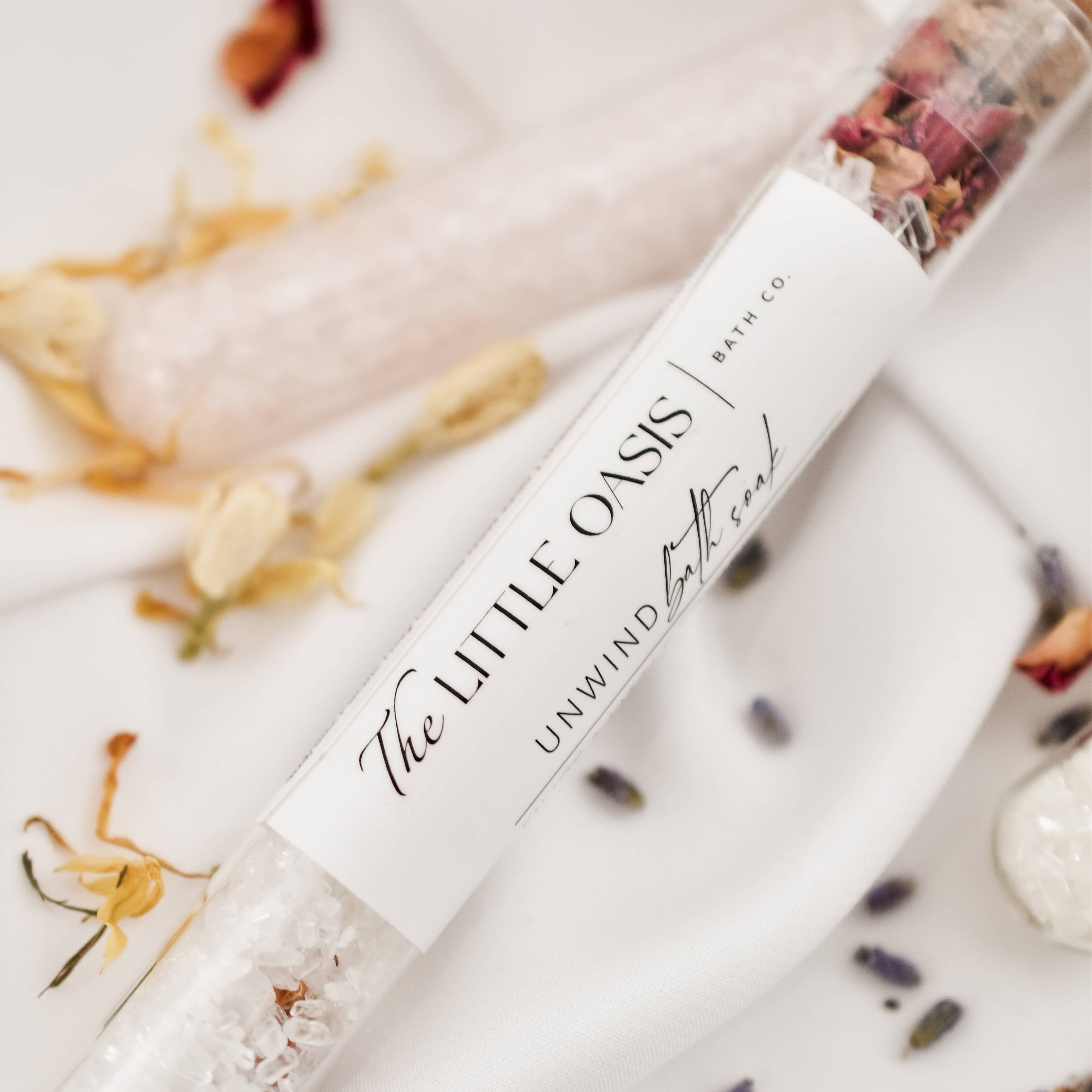 Twin bath bombs labeled 'The Little Oasis' with decorative elements on a light background