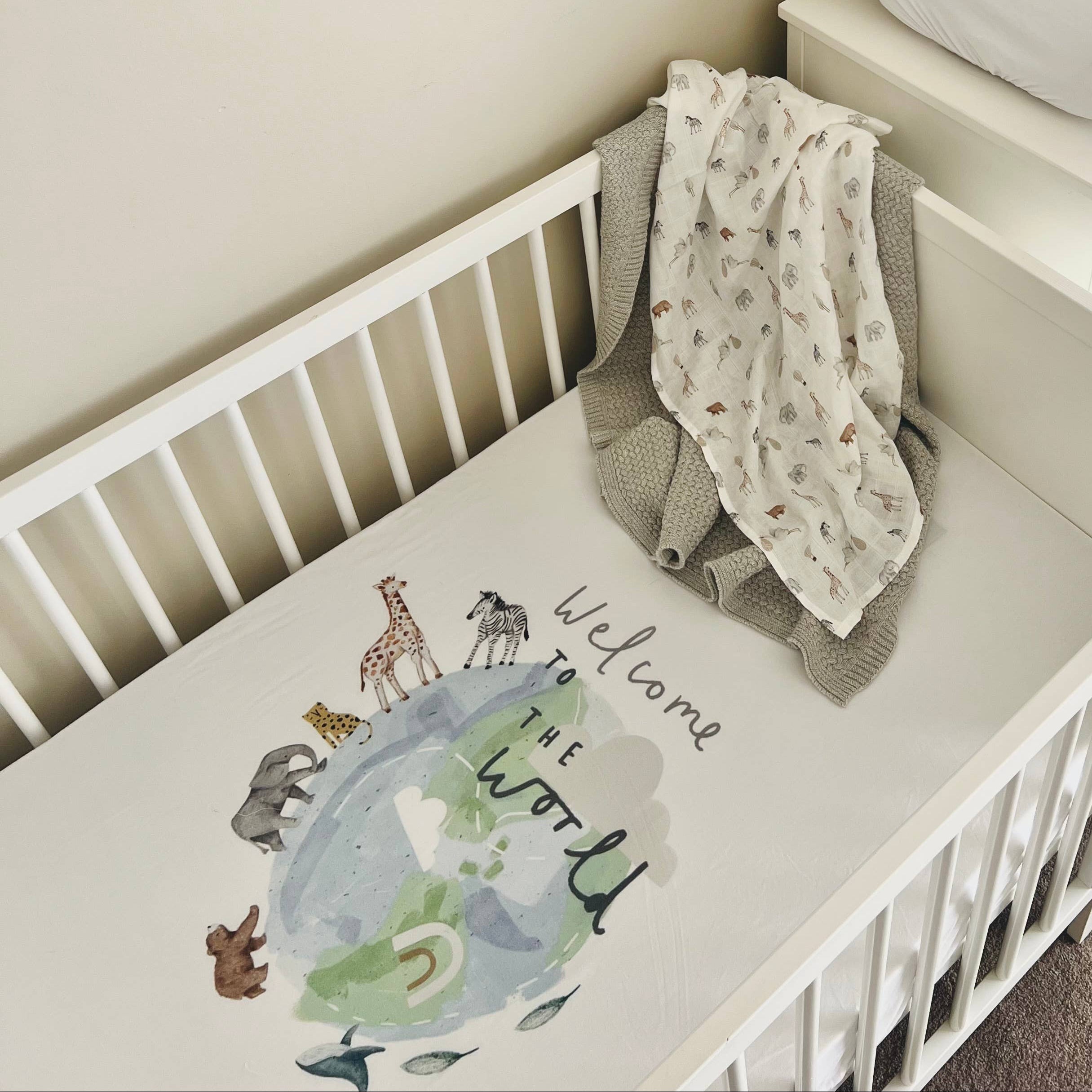 White crib with baby blanket and pillow in a nursery setting