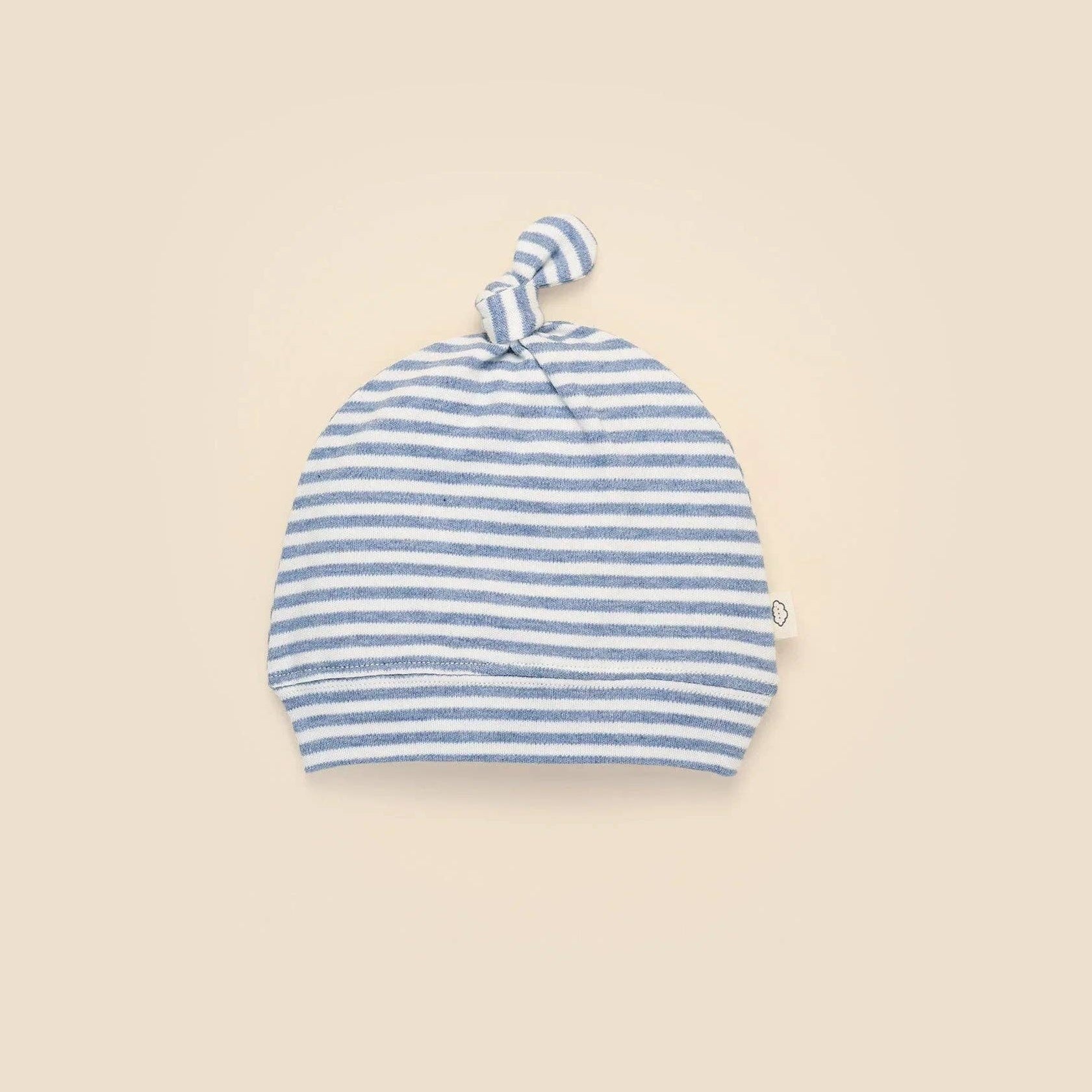 Blue and white striped baby hat on a beige background