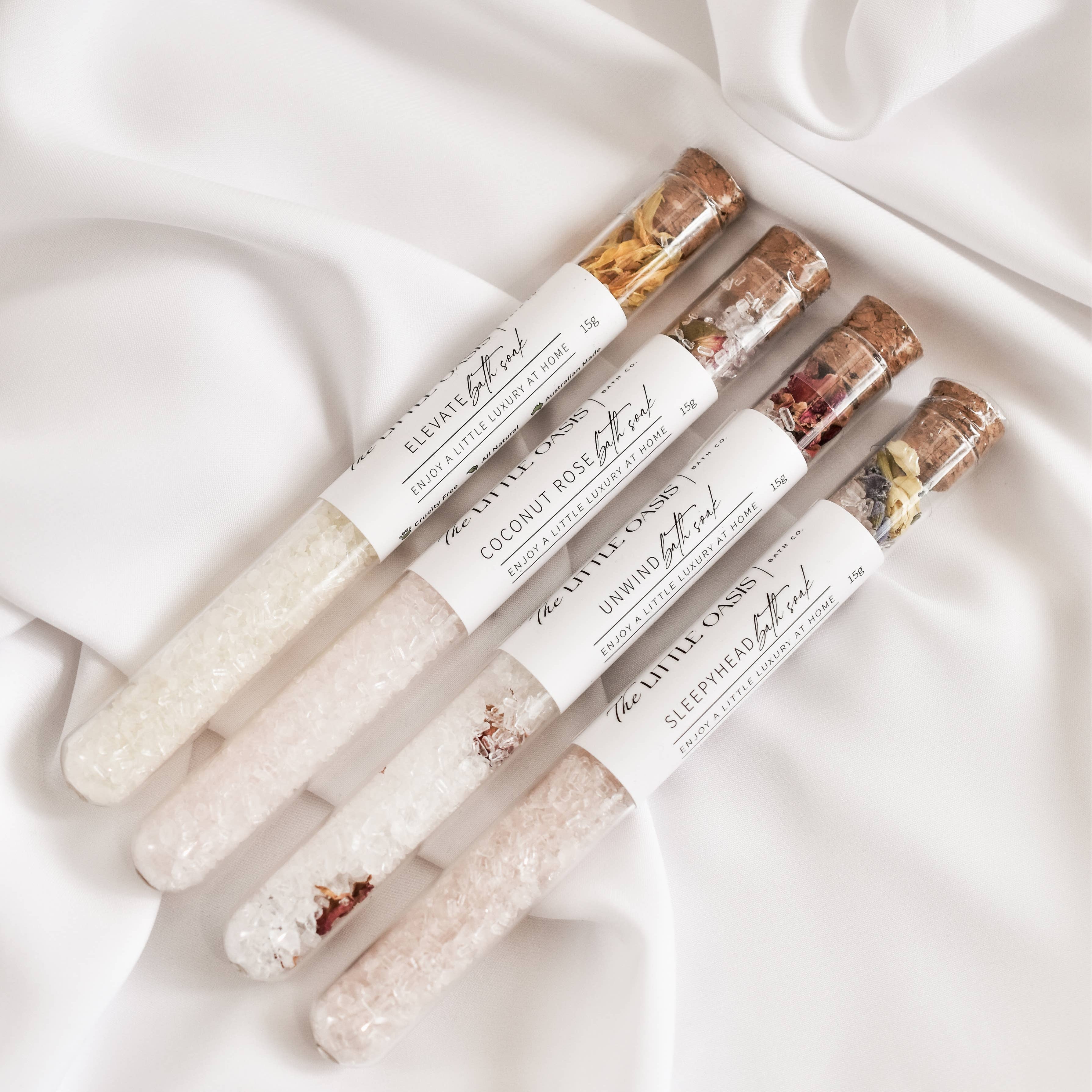 Set of lip balms with visible brand name on a white fabric background
