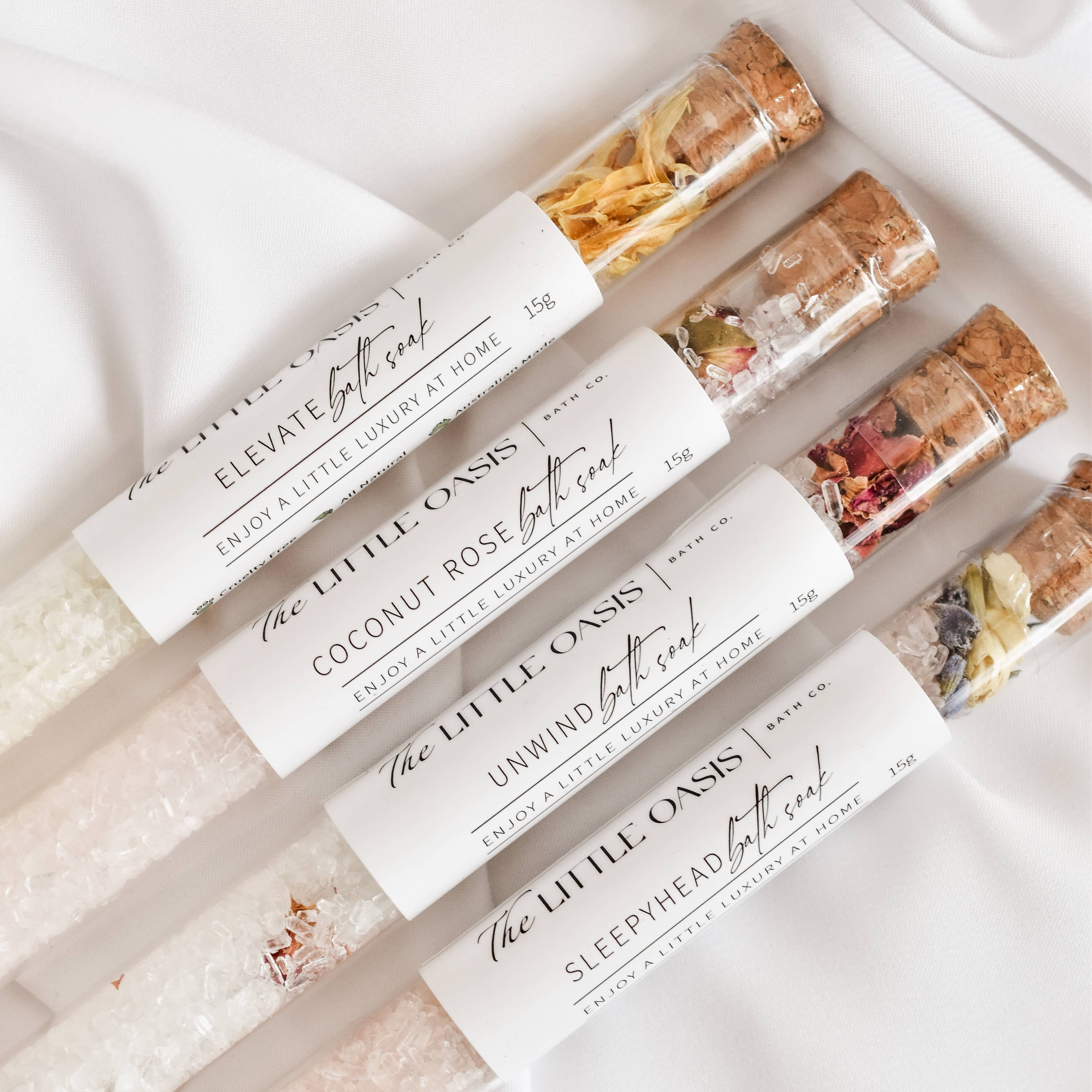Bath salts in clear tubes with labels on a white surface